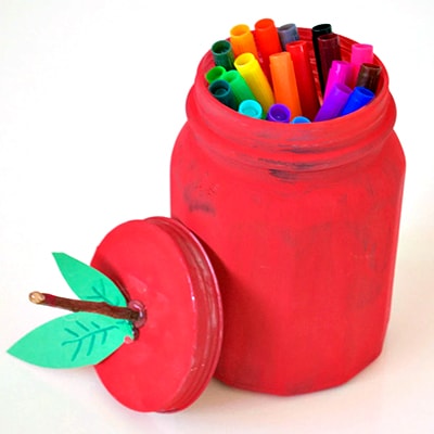 Canning jar painted like a red apple with markers inside